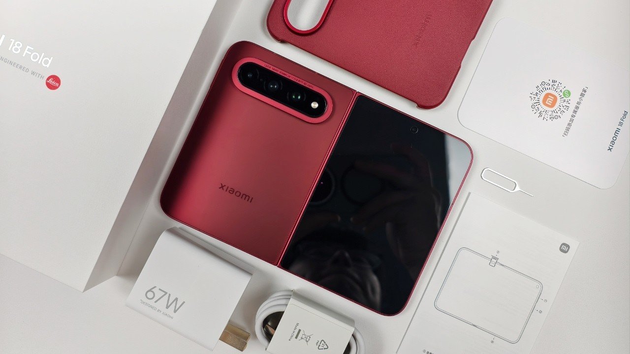 Xiaomi 18 Fold unboxing with the red foldable phone, 67W charger, USB-C cable, case, and accessories displayed in the box.